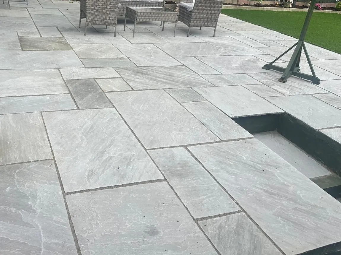 Grey sandstone patio with garden furniture