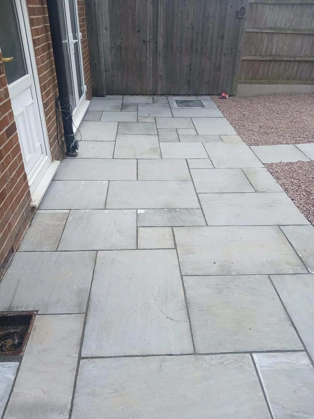 Grey sandstone patio and path beside a house