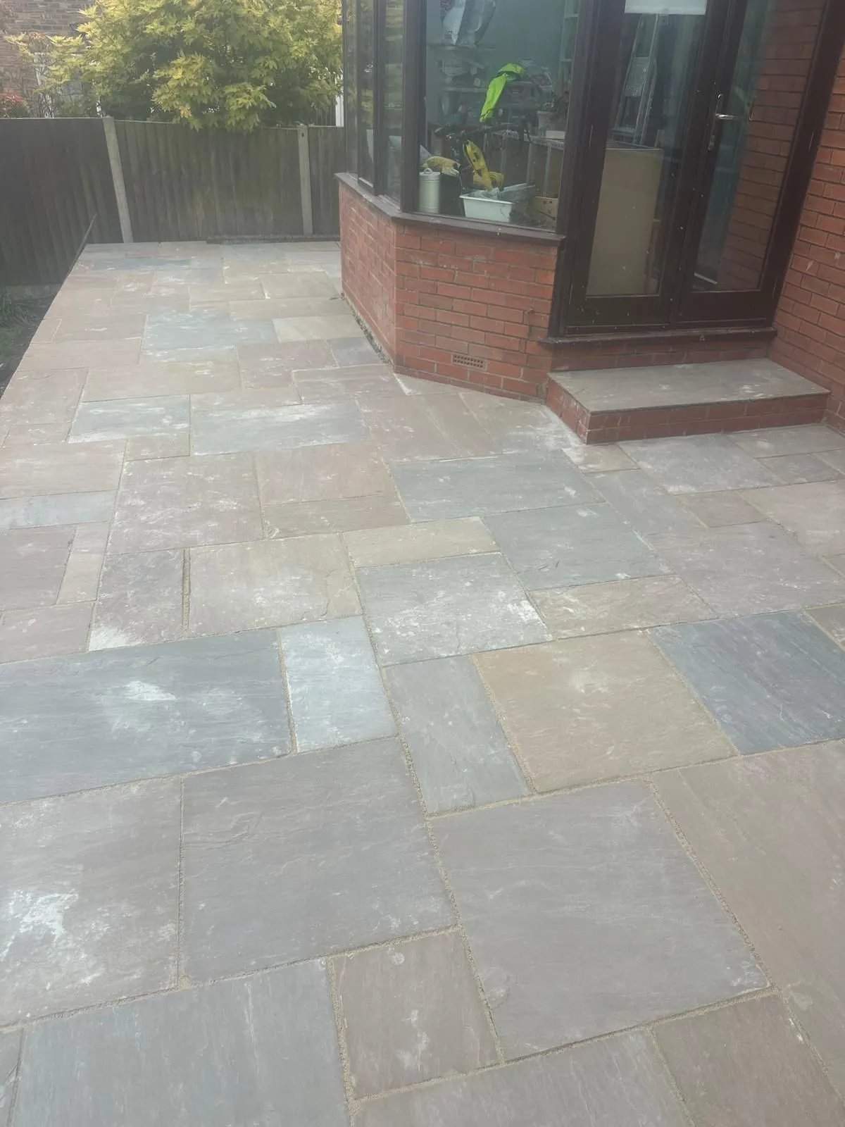 Multi colour sandstone patio by the back door