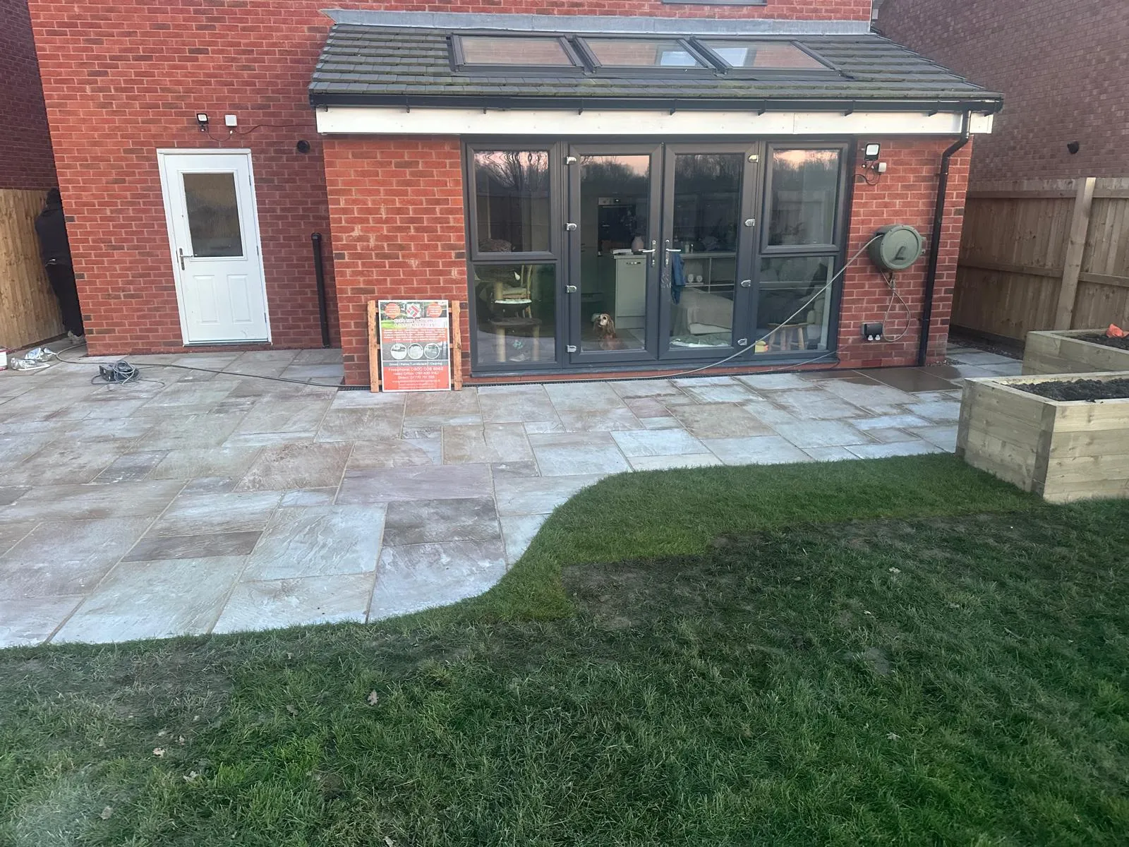 Light sandstone patio with a curved lawn edge