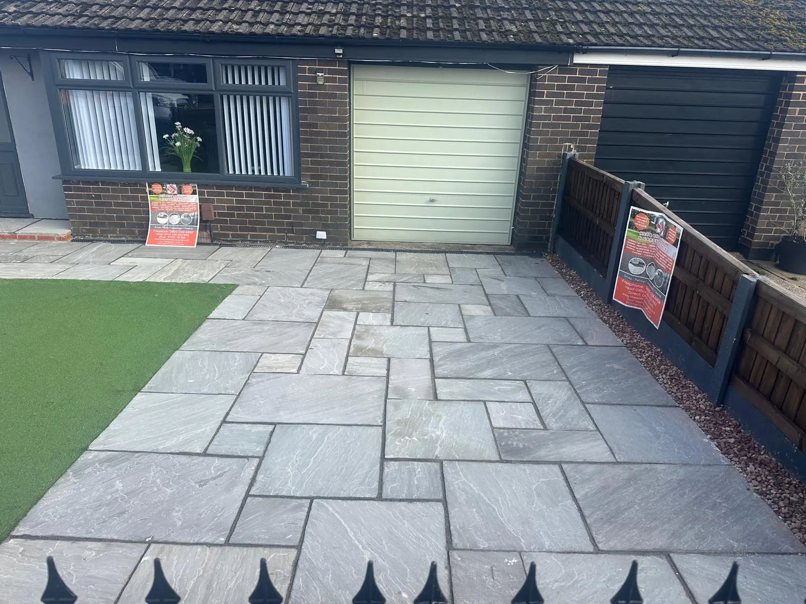 Grey sandstone front patio with an artificial grass panel