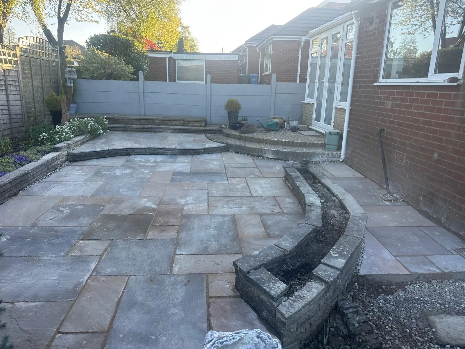 Curved stone walls and sandstone patio