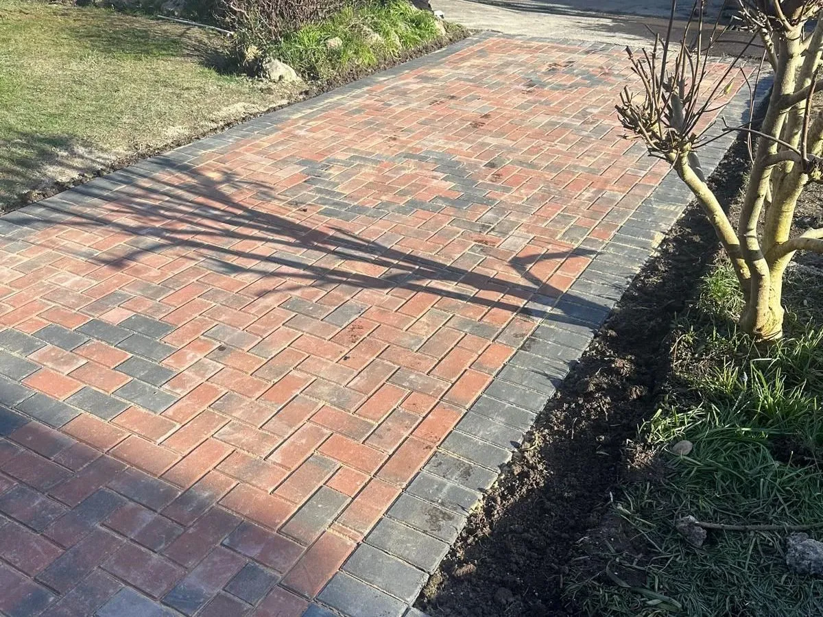 Red block paving with a charcoal border and diamond feature in Manchester