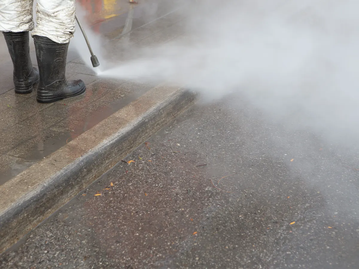 Pressure washer cleaning paving slabs