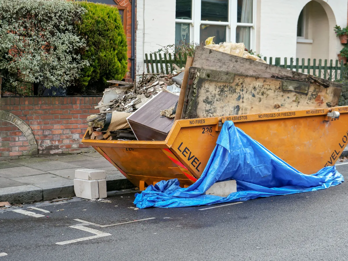 Skip loaded with waste outside a house
